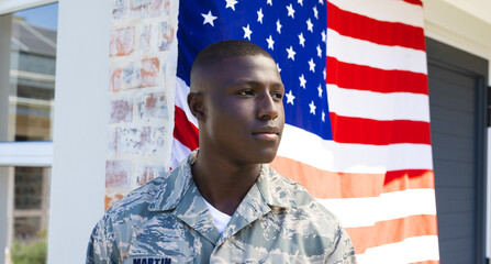 African american mid adult army soldier in camouflage clothing looking away standing against flag