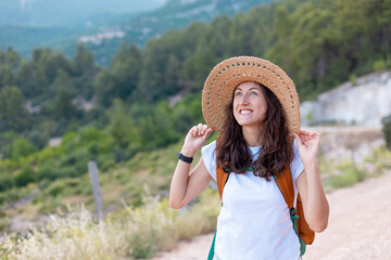 young girl in a straw hat and a backpack.