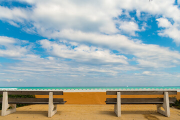 Fototapeta na wymiar empty wood bench with view on cloudy sky and sea