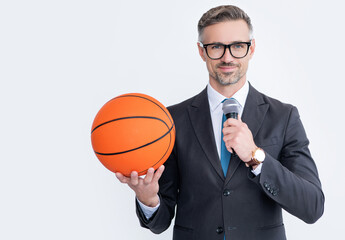 happy mature man in suit hold basketball ball and microphone isolated on white background