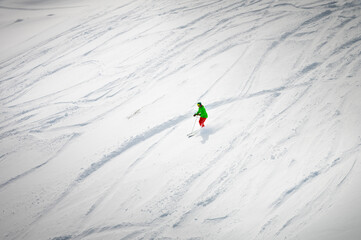 A skier descends a slope off-piste leaving a trail behind him, top view