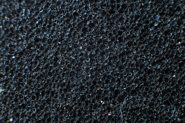 Close-up of packaging soft black material in shallow depth of field. Polyethylene foam avant-garde...