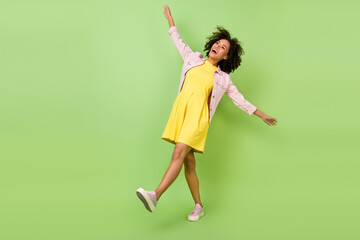 Full size photo of cheerful girl traveling go on walk date look up laughing feel free isolated on green color background