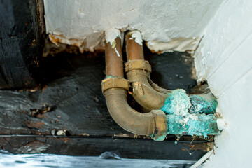 Shallow focus of a leaking hot water pipe showing the copper sulphate scale around the joint. Seen...