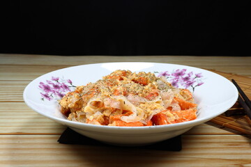 Traditional fried rice noodle mixed with crab stick and egg serving on the plate. 