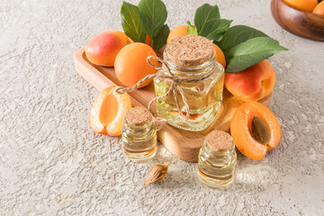 Organic natural apricot kernel oil in various bubbles on a wooden tray among ripe fruits. the concept of natural oils and self-care.