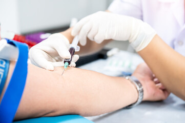 Close up hand of nurse, taking blood sample from a patient in the hospital.	