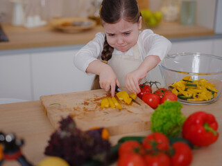 Young Girl Vlogger Making Social Media Video About Cooking At Home, looking on smartphone on tripod. episode about healthy eating. concept of attraction children to healthy diet of early age