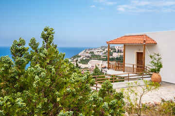Courtyard of a house with a red roof on the background of the sea