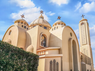 Exterior of modern El sama Eyeen Coptic Church in Sharm El Sheikh, Egypt. Facade of an Egyptian Orthodox temple against a blue sky - obrazy, fototapety, plakaty
