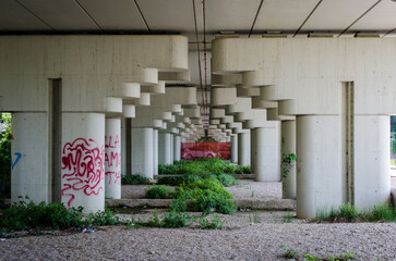 I piloni di un viadotto autostradale con dei graffiti creano una prospettiva urbana
