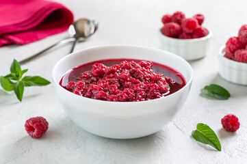 Delicious raspberry jam in a bowl on a light background. Traditional berry dessert