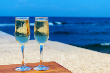Two champagne glasses against a sea in the evening. Copy space