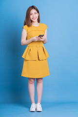 Full length photo of young Asian businesswoman on blue background