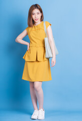 Full length photo of young Asian businesswoman on blue background
