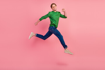 Fototapeta na wymiar Full length portrait of excited young man in shirt jumping running fast enjoy isolated over pastel color background