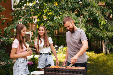 Family barbecue grill in the garden. Barbecue party. A family having fun and chatting on the grill.