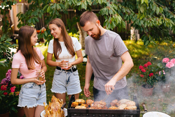 Family barbecue grill in the garden. Barbecue party. A family having fun and chatting on the grill.