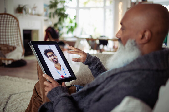 Senior man video chatting with doctor on digital tablet screen - Powered by Adobe