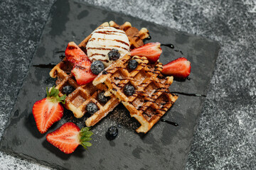 There are a new dessert on the black napkin on the grey table.