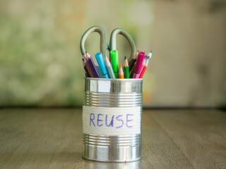 Can full of stationery, scissors, multicolored pens, pencils on blurred background. Sticker with...