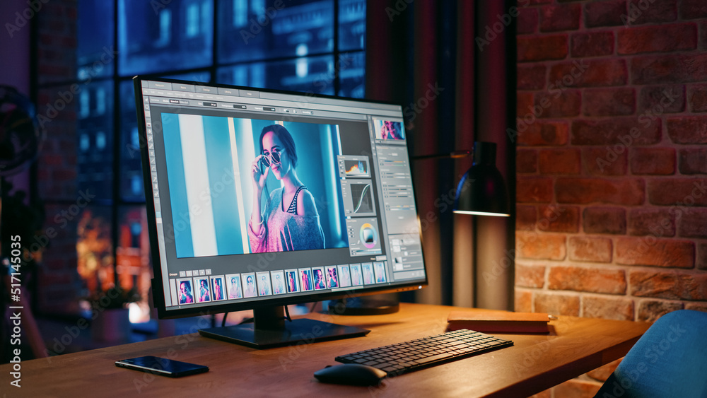 Poster modern loft office with night city view from big window. computer monitor with opened editing softwe