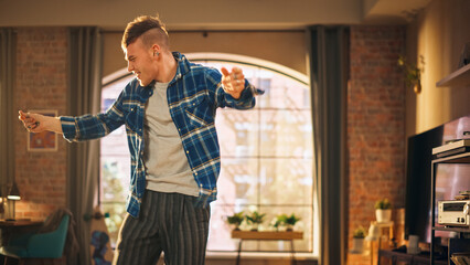 Portrait of Happy Handsome Young Man Dancing in Casual Home Clothes, Enjoying His Time Alone in His Loft Apartment. Recording Funny Viral Videos for Social Media. Medium Shot.