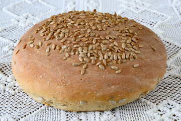 Homemade bread with sunflower seeds on a knitted tablecloth