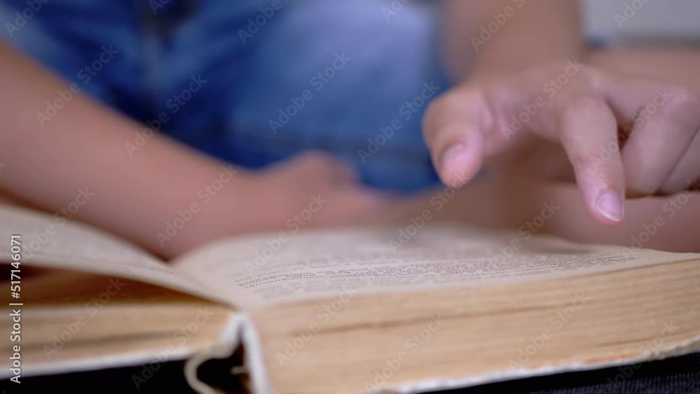 Poster child runs finger along page of book and reads quickly. reading remotely at home. self-isolation. on