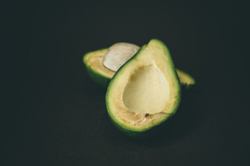 Ripe avocado halves on a dark background.