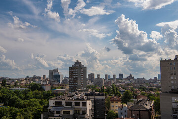 Beautiful rooftop view of Belgrade city residential area architecture and main street with white fluffy clouds. Belgrade, Serbia 09.06.2022