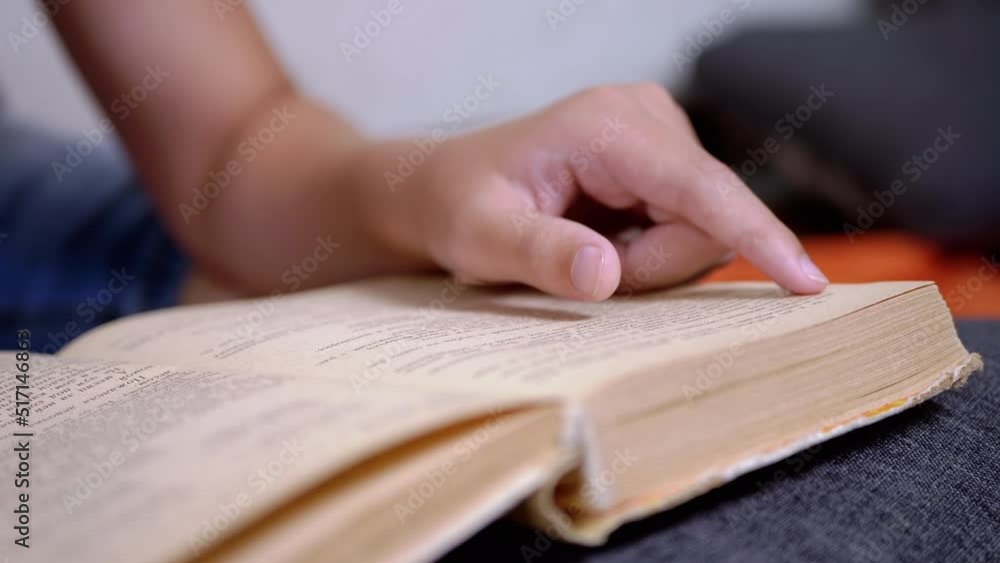 Poster child runs finger along page of book and reads quickly. reading remotely at home. self-isolation. on