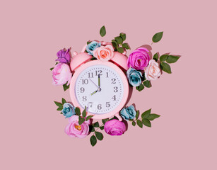 Vintage alarm clock creatively floral arranged on pastel pink background. Good morning colorful,...