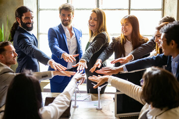 Top view of young business people putting their hands together, stack of hands, unity and teamwork concept, mixed age range and multicultural team work