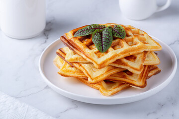 Homemade delicious belgian waffles on the white table. Freshly baked belgian waffles