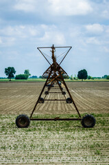 Un irrigatore a pioggia in un campo della campagna lombarda lungo la Via Postumia, cammino che...