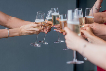 friends clink champagne glasses. Bride with jewelry and wedding ring