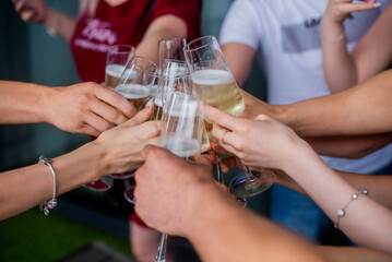 friends clink champagne glasses. Bride with jewelry and wedding ring