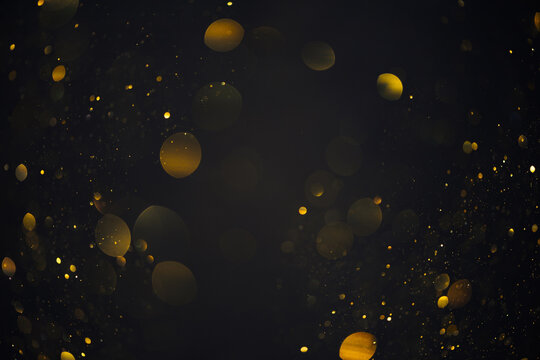 Gold glitter bokeh shiny dust particles lights abstract dark background © nevodka.com