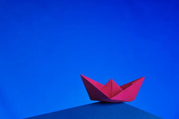 red paper boat on blue sky
