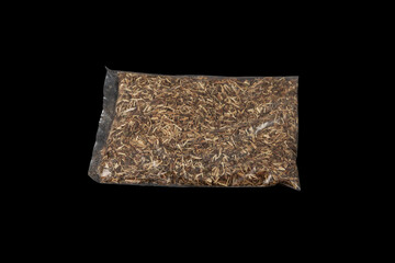 Dried herbal tea of Agrimonia eupatoria or common agrimony in transparent plastic bag on dark...