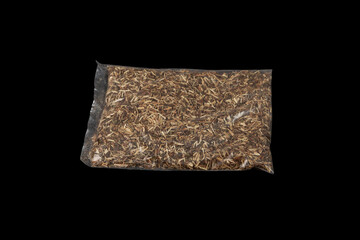 Dried herbal tea of Agrimonia eupatoria or common agrimony in transparent plastic bag on dark background. Selective focus. Medicinal plant. Used in alternative medicine