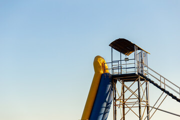 Observation wooden tower with a lifeguard boat on the beach against the blue sky