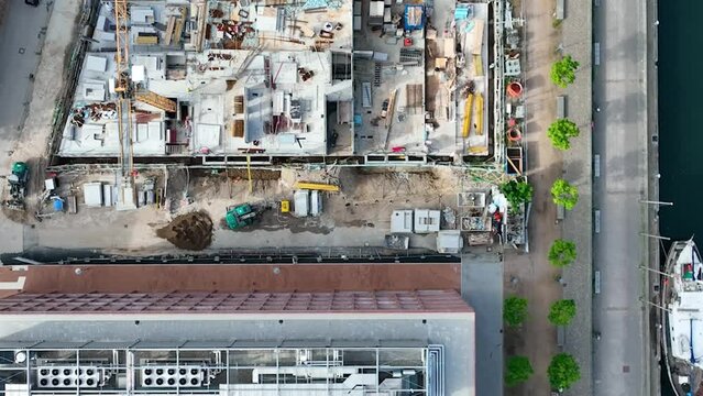 Aerial, top down, drone shot, over a construction site in harbour. Construction and development concept. Aerial shot  above new building under construction in Kiel harbour, Schleswig-Holstein. 