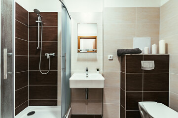 Small simple bathroom with mirror.  Bathroom has square sink, large and spacious shower with...