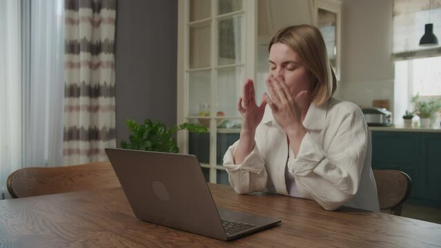 Young adult caucasian woman reading bad news on her laptop computer feeling sad and depressed