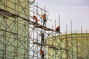 Worker male assembly in progress storage new tank  oil inspection scaffolding