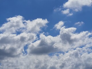 Naklejka na ściany i meble Beautiful fluffy white clouds at blue sky with copy space.