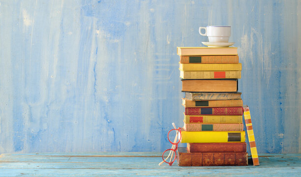 stack of vintage books, cup of coffee and spectacles, reading, education, learning, home office concept, large free copy space.