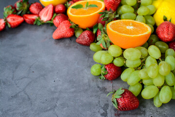Various fruits and berries on dark background in the kitchen